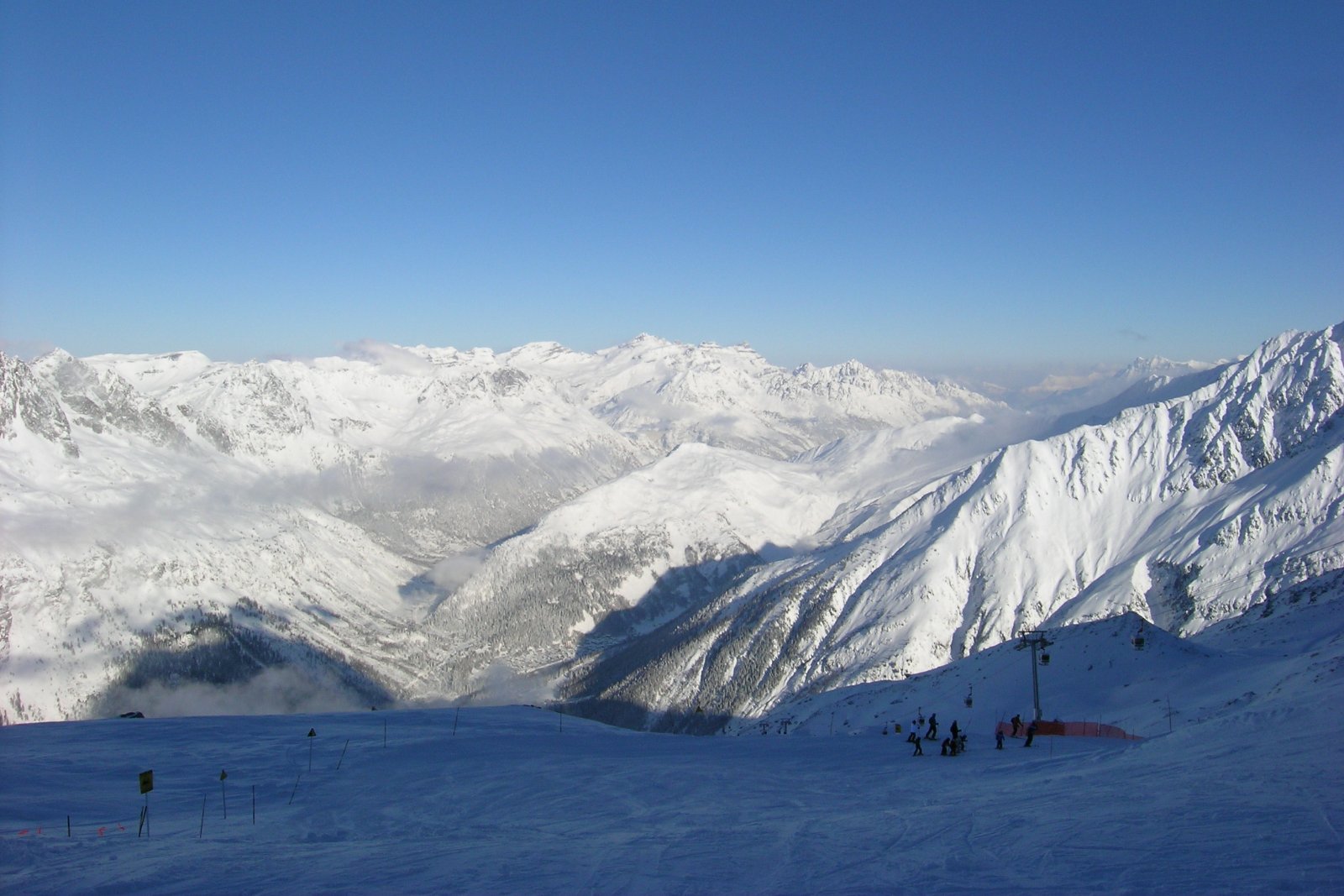 Photo : Daniel Simpson, CC BY 2.0, Wikimedia Commons Skieurs sur une piste du domaine de Chamonix, face à la vallée et aux sommets enneigés