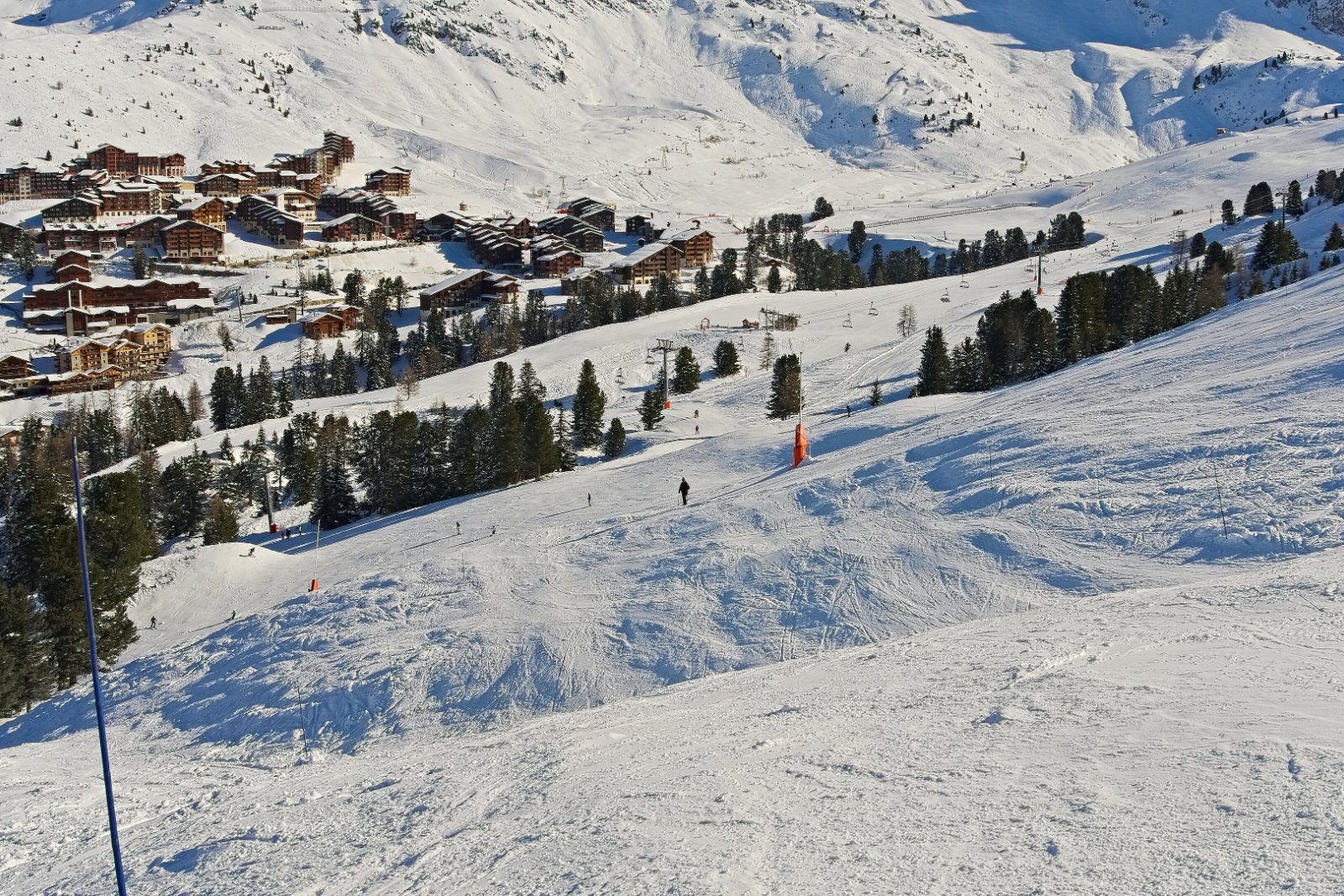 Piste dam&eacute;e descendant vers Belle Plagne, bord&eacute;e de sapins