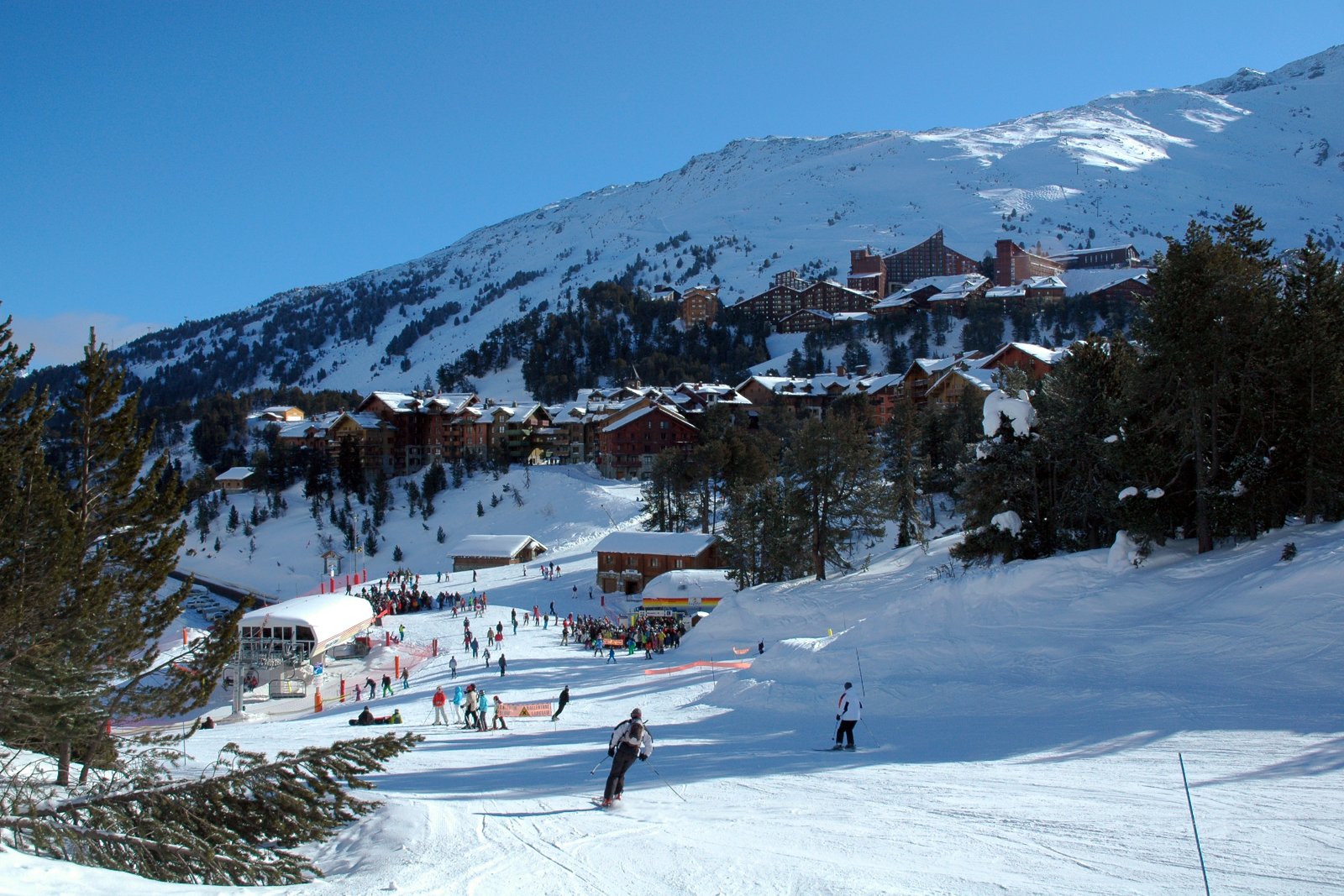 Photo : DimiTalen, CC0, Wikimedia Commons Skieurs en bas de la piste Edelweiss, avec Arc 1950 et Arc 2000 en arrière-plan