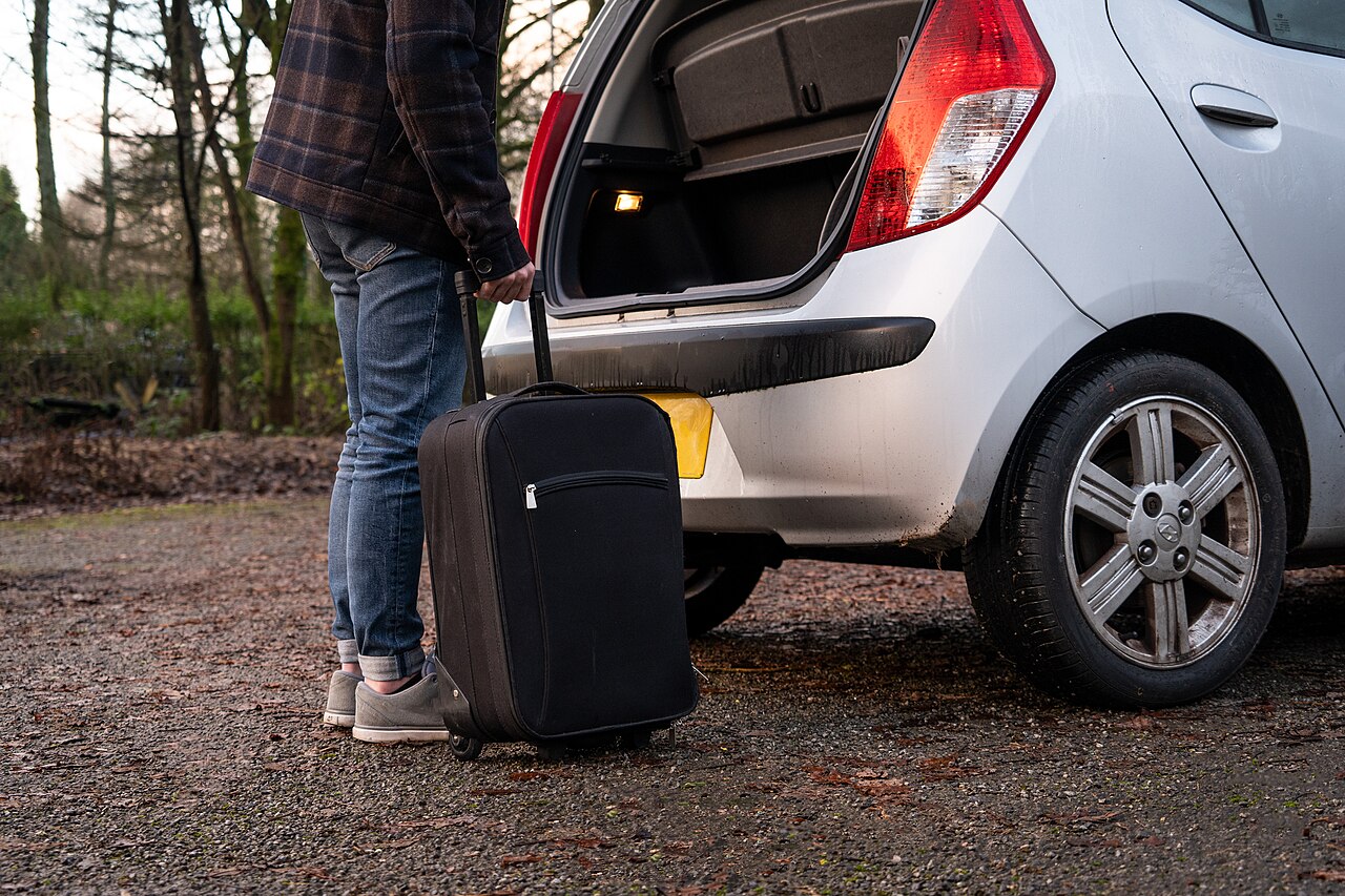 Valise chargée dans le coffre avant les vacances Valise chargée dans le coffre d'une voiture compacte avant un départ en vacances
