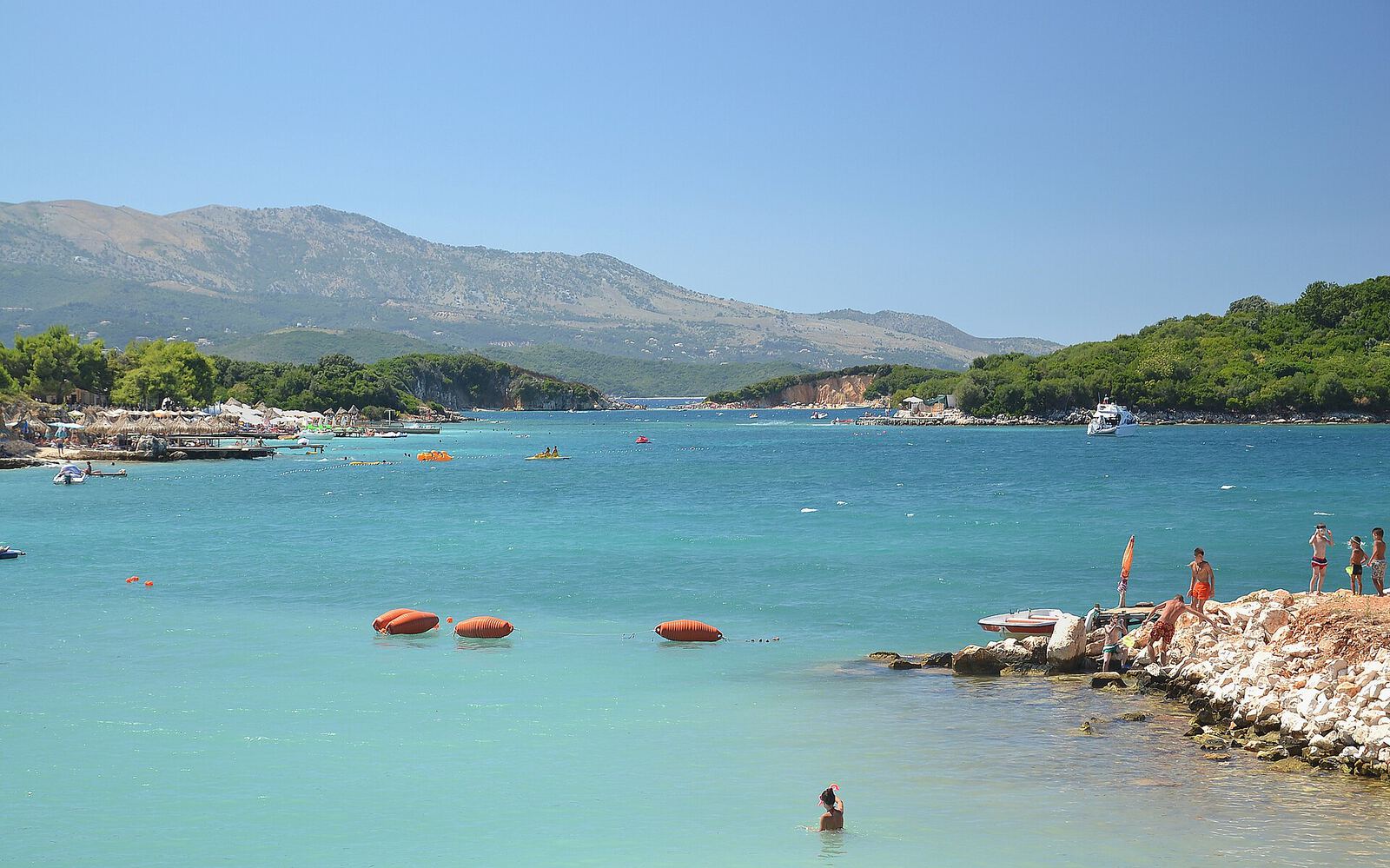 La baie de Ksamil, en Albanie, avec son eau turquoise, ses îlots boisés et les montagnes en arrière-plan